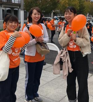 イメージカラーのオレンジ色のTシャツを着用した学生