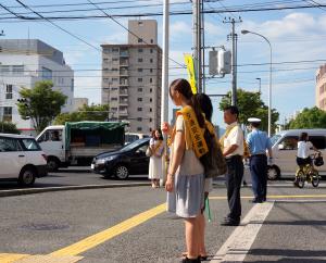 交通安全のたすきをかけ，声かけを実施