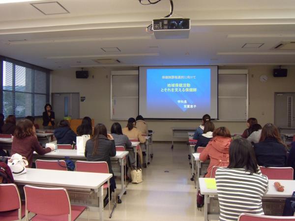 説明会会場で学科長のあいさつを聞く学生たち